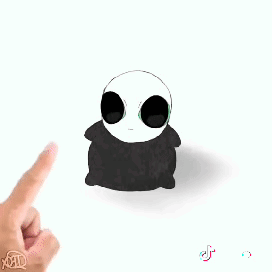 a person 's finger is pointing at a stuffed animal with sunglasses on .