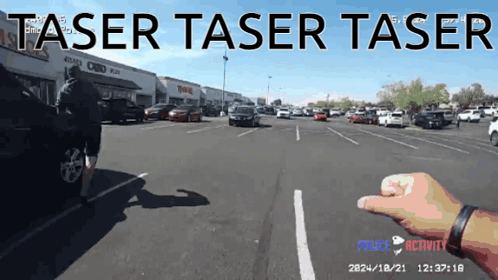 A Person 'S Hand Is Pointing At A Car In A Parking Lot With The Words Taser Taser Taser GIF