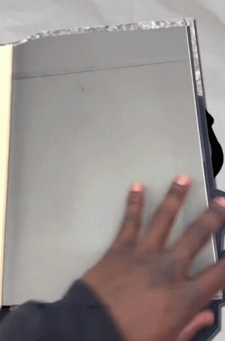 A Person 'S Hand Is Reaching Out Towards A Book GIF