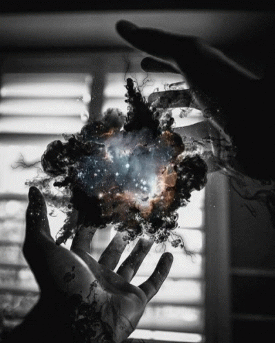 A Person 'S Hand Is Reaching Out Towards A Galaxy GIF