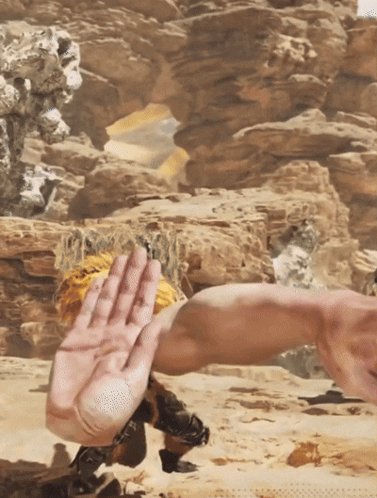 A Person 'S Hand Is Reaching Out Towards Another Person 'S Arm In The Desert GIF