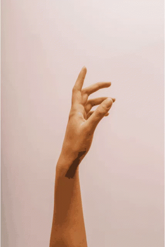 a person 's hand is reaching up in the air