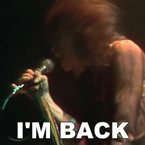 A Person Singing Into A Microphone With The Words I 'M Back Below Them GIF