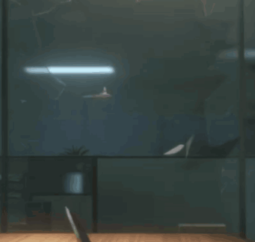 A Person Sitting At A Desk In A Dark Room GIF