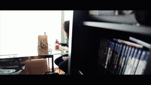 A Person Sitting At A Table With A Bag That Says ' A ' On It GIF
