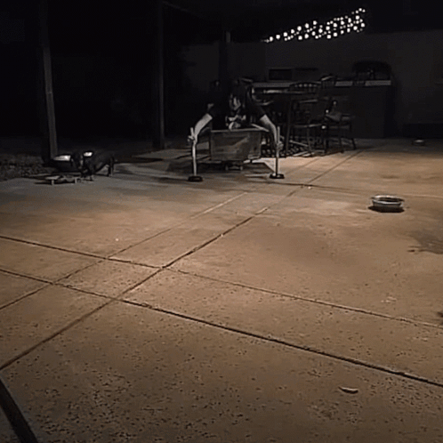 A Person Sitting On A Wooden Box On A Patio GIF
