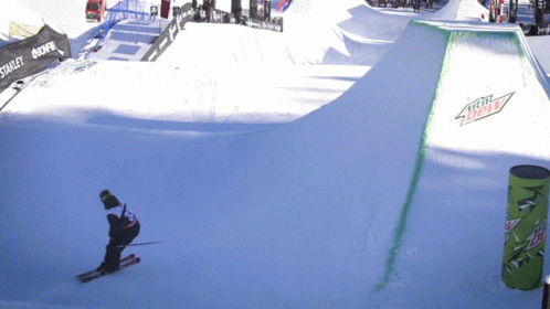 A Person Skiing Down A Snowy Slope With A Mountain Dew Sign On The Side GIF