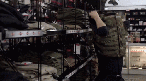 A Person Standing In Front Of A Shelf With Clothes On It That Says Ctv GIF