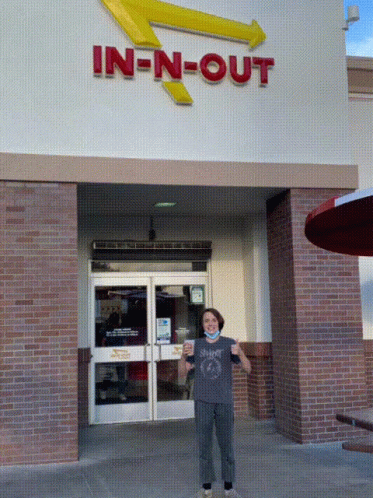 A Person Standing In Front Of An In N Out Restaurant GIF