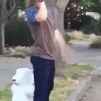 A Person Standing Next To A Fire Hydrant Holding A Bottle GIF