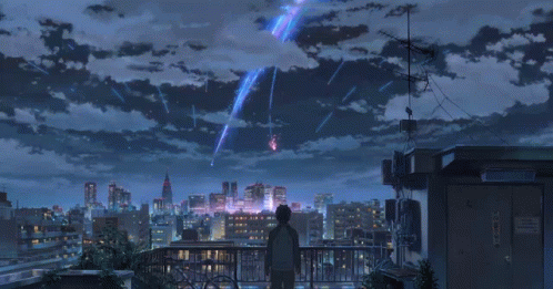 A Person Standing On A Balcony Looking At A City Skyline GIF