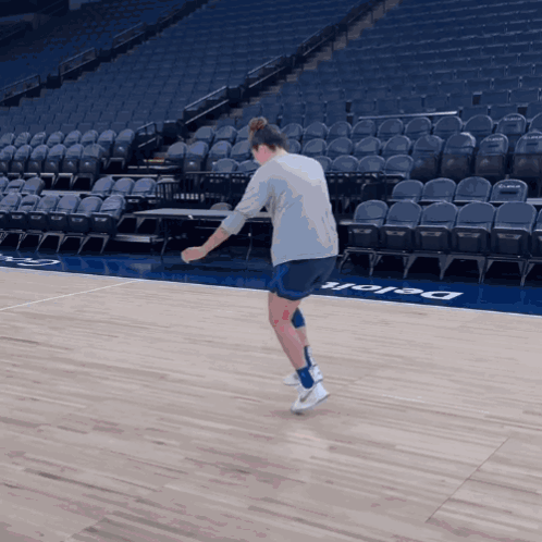 A Person Standing On A Basketball Court That Has The Word Delaware On The Floor GIF