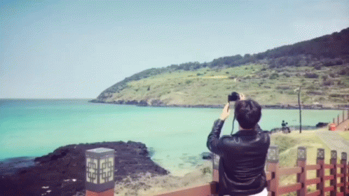 A Person Taking A Picture Of A Body Of Water GIF