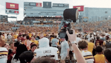 a person taking a picture of a crowd with a laneux jersey on