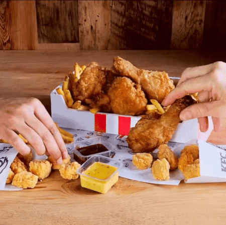 A Person Taking A Piece Of Fried Chicken Out Of A Box That Says Kfc GIF