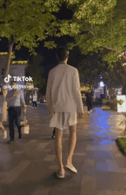 A Person Walking Down A Sidewalk With A Tiktok Logo On The Bottom GIF