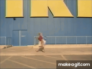 a person walking in front of a large yellow sign that says ikea