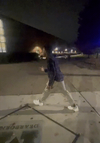A Person Walking On A Sidewalk With A Sign That Says Dragon GIF