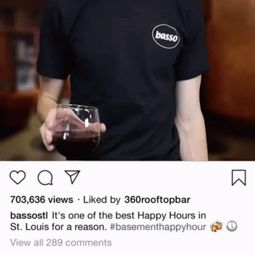 a person wearing a basso shirt holds a glass of wine