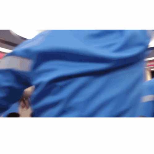 A Person Wearing A Blue Jacket With Reflective Stripes GIF