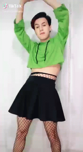 A Person Wearing A Green Crop Top And A Black Skirt Is Dancing . GIF