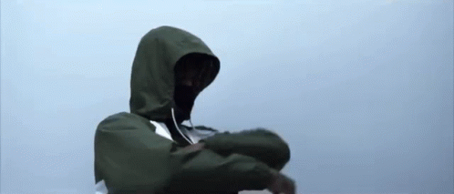 A Person Wearing A Green Jacket With A Hood Is Standing In The Rain . GIF