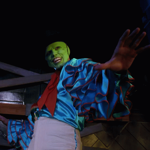 A Person Wearing A Green Mask And A Blue Shirt GIF