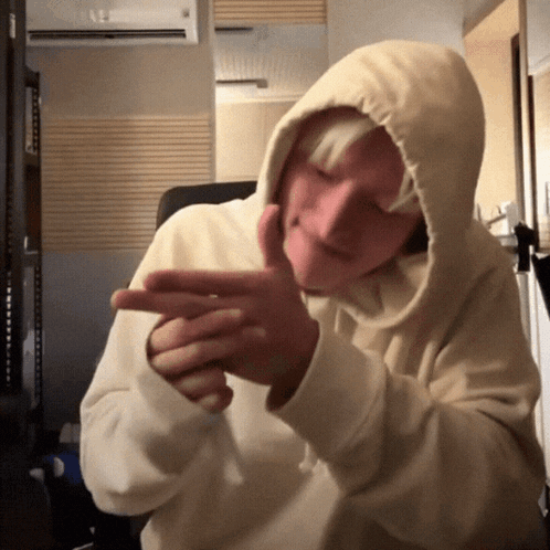 A Person Wearing A Hooded Sweatshirt Is Making A Funny Face GIF