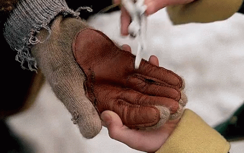 A Person Wearing A Knitted Glove Is Holding Another Person 'S Hand GIF