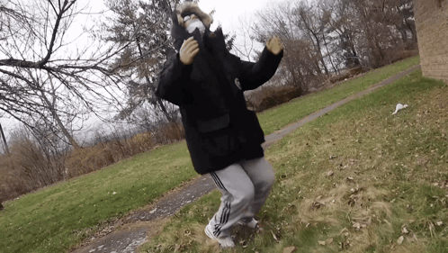 a person wearing a mask and a black jacket is dancing