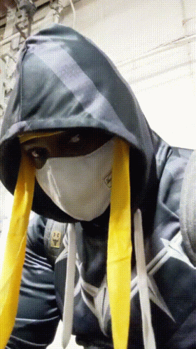 A Person Wearing A Mask And A Hoodie Has A Sticker On Their Shirt That Says ' Spiderman ' GIF