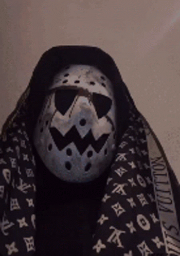 A Person Wearing A Mask And A Louis Vuitton Scarf Around Their Neck GIF