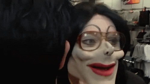A Person Wearing A Mask And Glasses Looks At Another Person 'S Face GIF