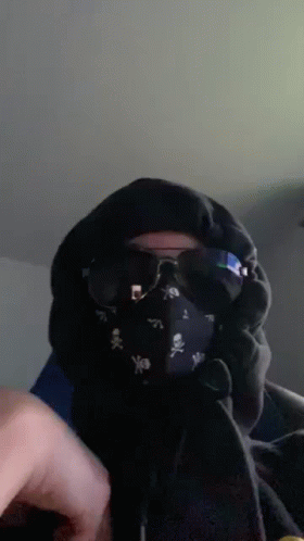 A Person Wearing A Mask And Sunglasses With Skulls On It GIF
