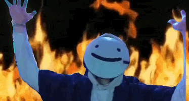 A Person Wearing A Mask With A Smiley Face Is Standing In Front Of A Fire . GIF