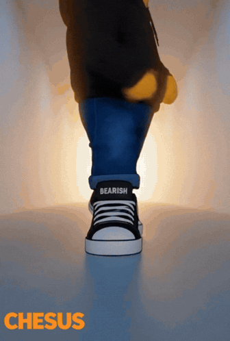 a person wearing a pair of black and white sneakers with the word bearish on the side
