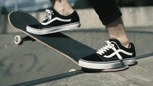 A Person Wearing A Pair Of Black And White Vans Shoes Rides A Skateboard GIF