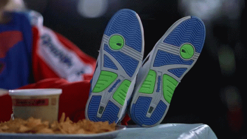 A Person Wearing A Pair Of Reebok Shoes Laying On A Table GIF
