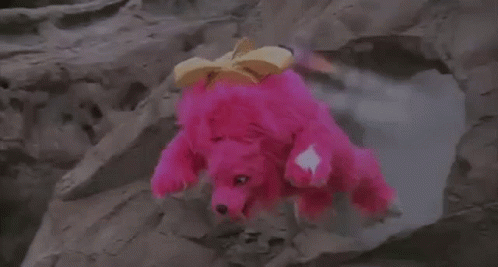 Person In Pink Costume Standing On Rocky Hill GIF