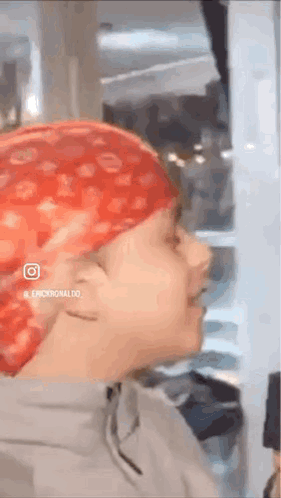 A Person Wearing A Red Bandana On Their Head Is Standing In A Room . GIF