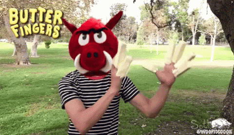a person wearing a red boar mask with butter fingers written on the top