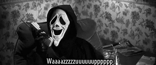 A Person Wearing A Scream Mask Is Talking On A Cell Phone While Sitting On A Couch . GIF