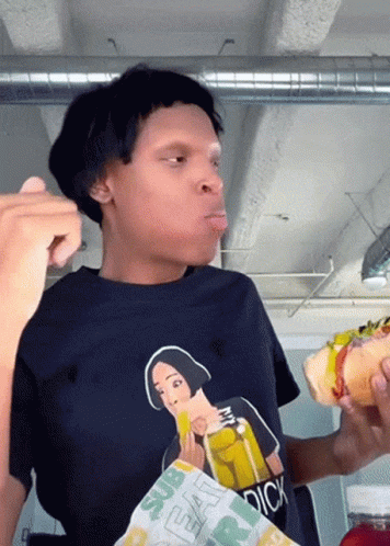A Person Wearing A Shirt That Says Dick Is Eating A Sandwich GIF