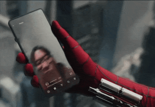 A Person Wearing A Spiderman Glove Is Holding A Phone GIF
