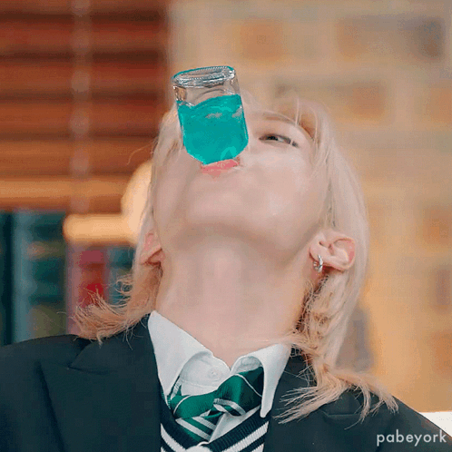 A Person Wearing A Suit And Tie Is Drinking From A Glass GIF