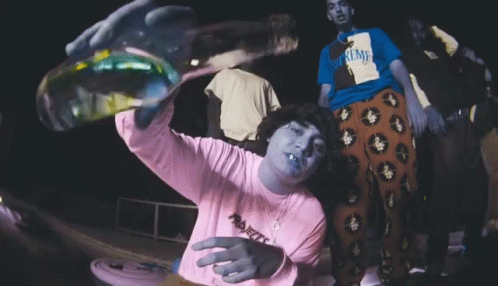 A Person Wearing A Supreme Shirt Is Holding A Bottle GIF