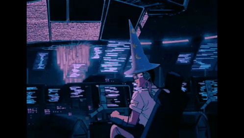 A Person Wearing A Witch Hat Is Sitting In Front Of A Computer Monitor GIF