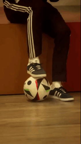A Person Wearing Adidas Shoes Is Balancing A Soccer Ball On Their Knee GIF