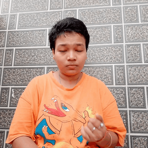 A Person Wearing An Orange Shirt With A Picture Of A Dragon On It GIF