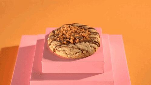 a person wearing black gloves pours a cookie with a spoon